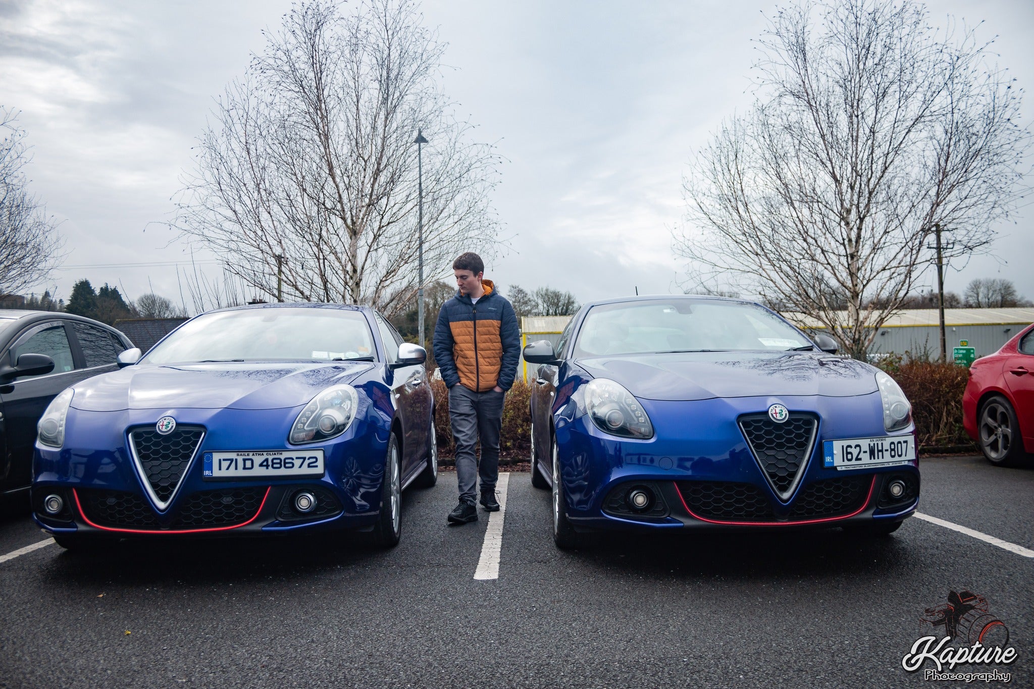 Cork Mechanic standing between two Alfa Romeos at a Car Meet Ireland 2023