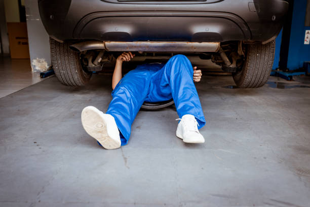 Mechanic on the floor working on a car